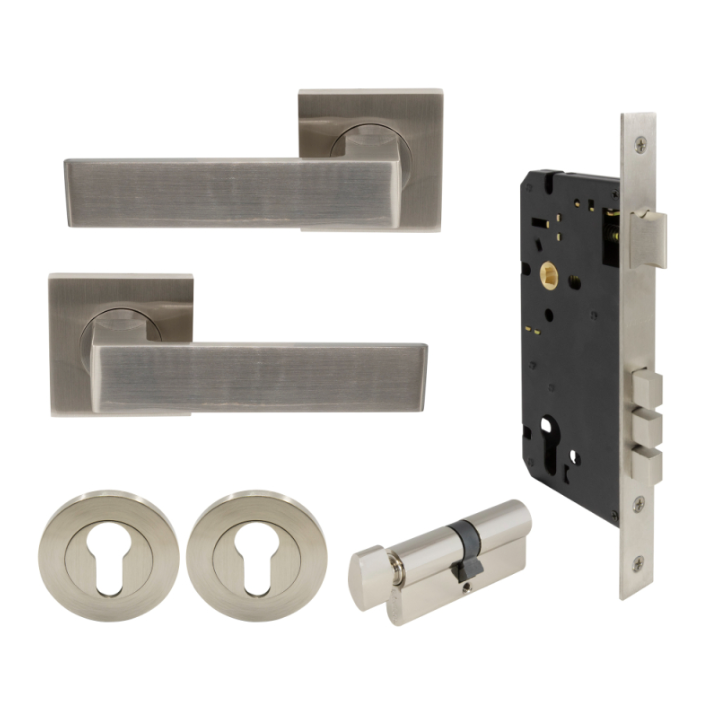 Set of door handles, lock mechanism, and key cylinder on a white background